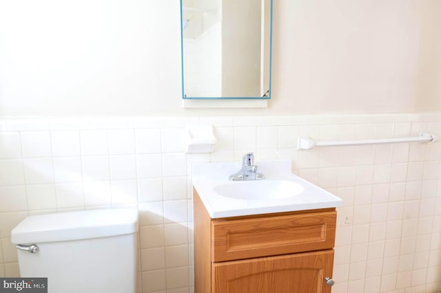 bathroom featuring backsplash, vanity, toilet, and tile walls