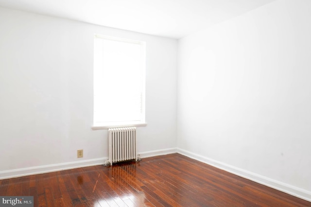 unfurnished room with wood-type flooring and radiator heating unit