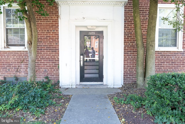 view of exterior entry with brick siding