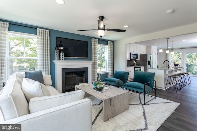 living room with dark hardwood / wood-style floors, a wealth of natural light, and ceiling fan