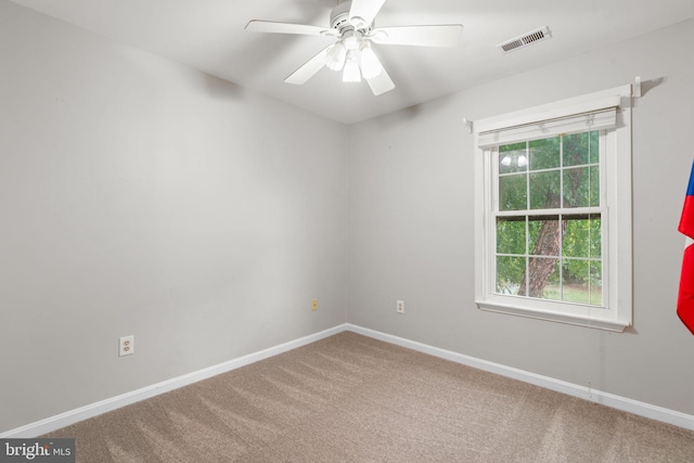 carpeted spare room featuring ceiling fan, baseboards, and visible vents