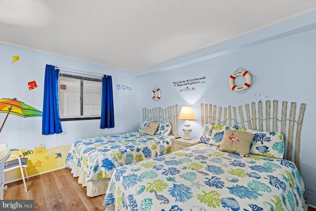 bedroom featuring hardwood / wood-style flooring and a textured ceiling