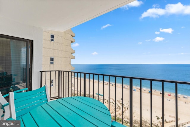 balcony featuring a water view and a view of the beach