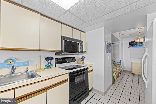 kitchen featuring light tile patterned flooring, sink, and black appliances