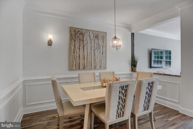 dining space with dark wood-type flooring, crown molding, and an inviting chandelier