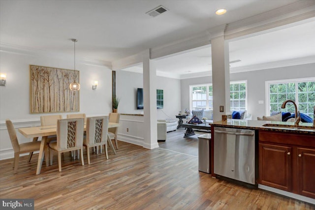 kitchen with light wood-type flooring, stainless steel dishwasher, pendant lighting, sink, and ornamental molding