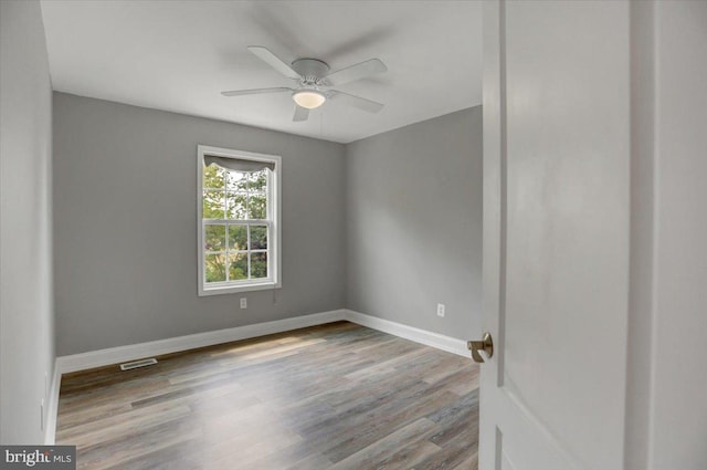 empty room with ceiling fan and wood-type flooring