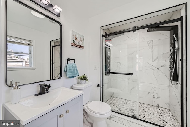 bathroom featuring vanity, toilet, and a shower with shower door