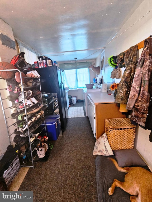 interior space featuring black refrigerator and dark colored carpet