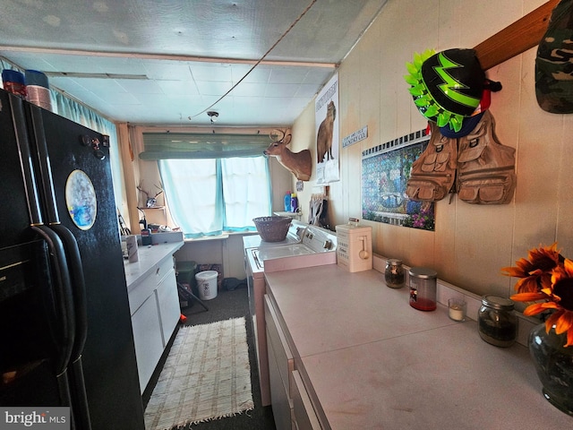 kitchen with black fridge with ice dispenser and washing machine and clothes dryer