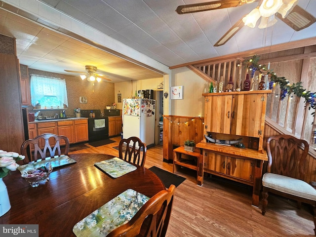 dining area featuring wood-type flooring, sink, and ceiling fan