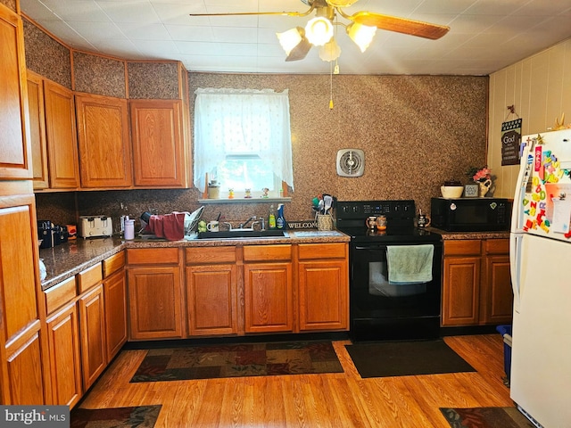 kitchen with sink, wood-type flooring, black appliances, and ceiling fan