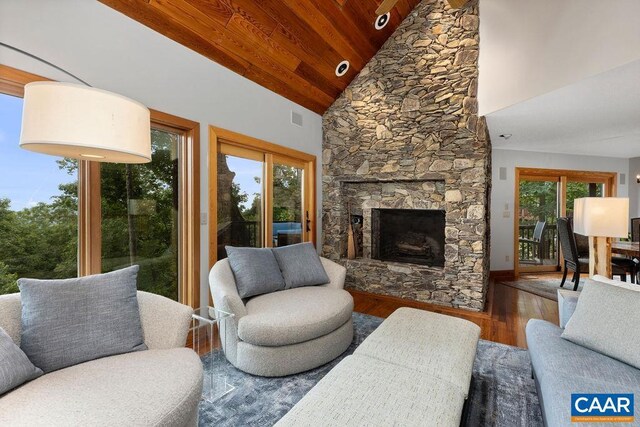 living room with wood ceiling, a stone fireplace, wood-type flooring, and high vaulted ceiling