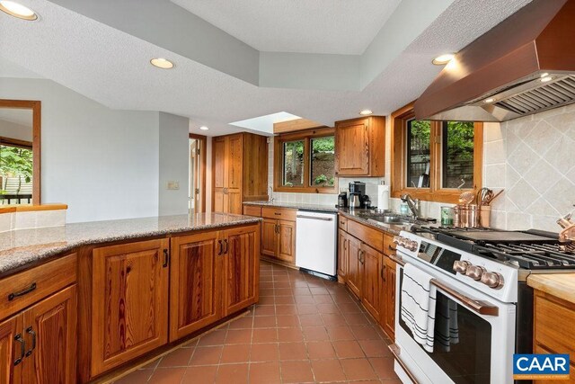 kitchen with tile patterned flooring, white appliances, backsplash, light stone countertops, and wall chimney exhaust hood