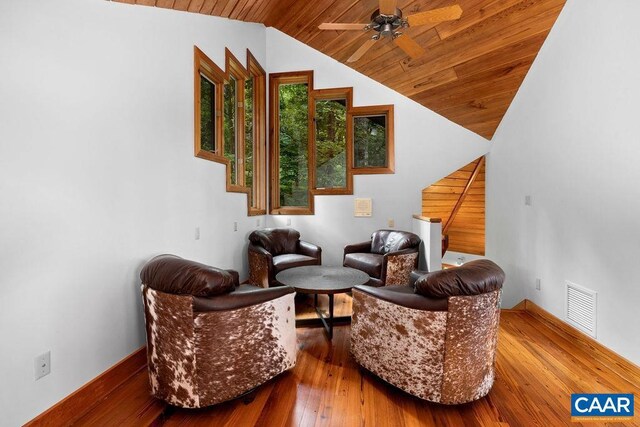 living area featuring hardwood / wood-style flooring, wooden ceiling, and ceiling fan