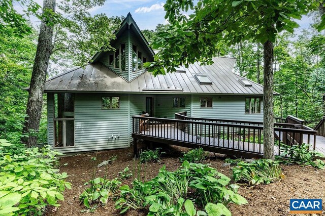 rear view of property featuring a wooden deck