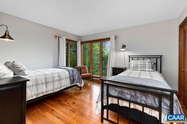 bedroom featuring a textured ceiling and wood-type flooring