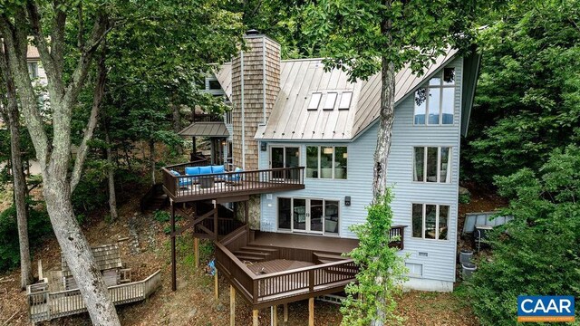 rear view of house featuring a wooden deck