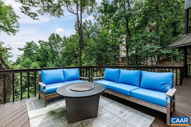 deck featuring an outdoor living space with a fire pit