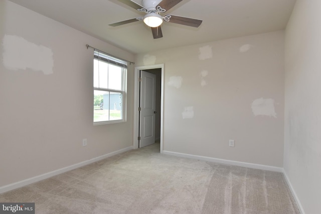 carpeted empty room featuring ceiling fan