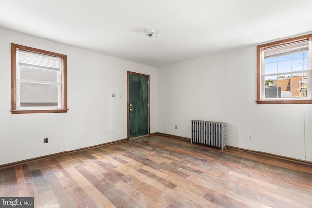 spare room with radiator and hardwood / wood-style flooring