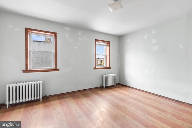 empty room with radiator heating unit and wood-type flooring