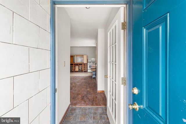 interior space featuring dark tile patterned floors and tile walls