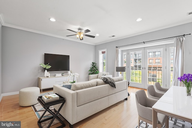 living room featuring ceiling fan, light hardwood / wood-style floors, and ornamental molding