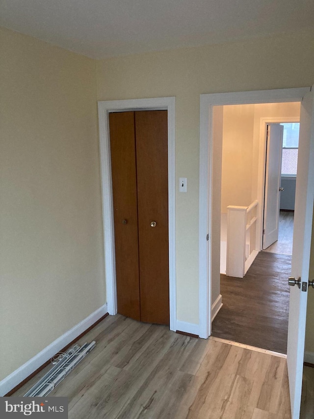 unfurnished bedroom with hardwood / wood-style flooring and a closet