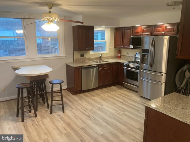 kitchen featuring sink, light wood-type flooring, ceiling fan, and stainless steel appliances