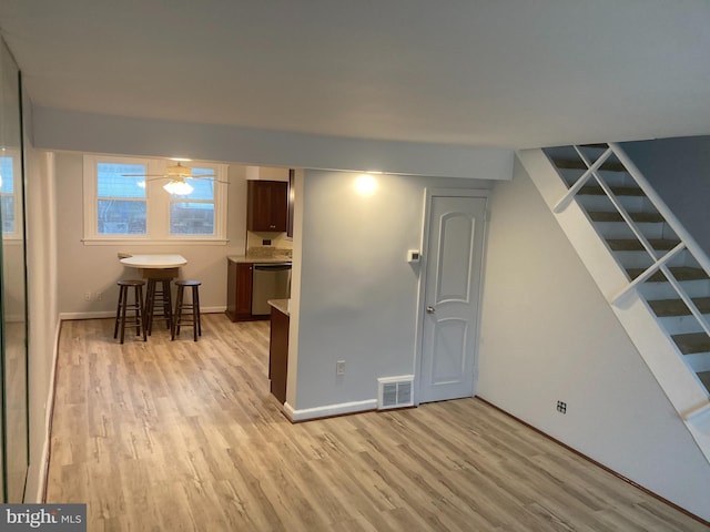 basement with light hardwood / wood-style floors and ceiling fan