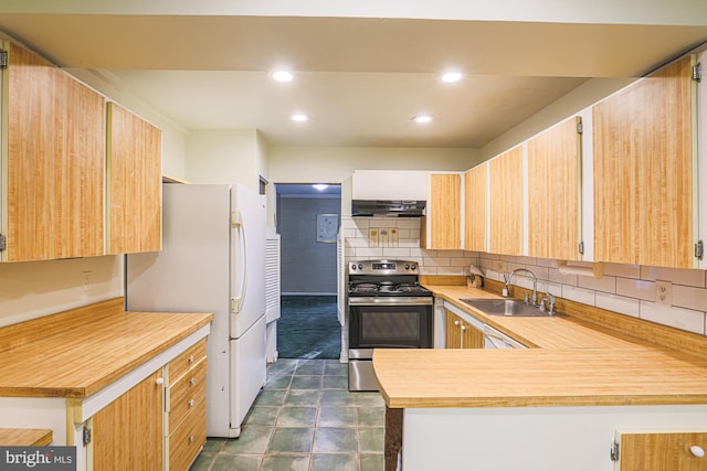 kitchen with electric range, freestanding refrigerator, a sink, under cabinet range hood, and backsplash