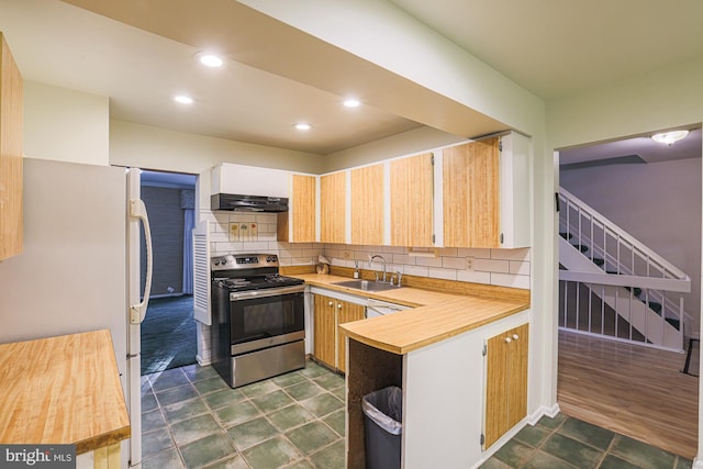 kitchen featuring freestanding refrigerator, light countertops, stainless steel electric range oven, and under cabinet range hood