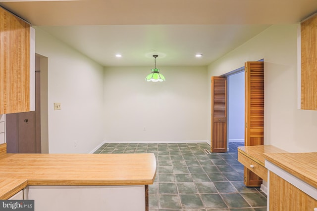 kitchen with baseboards, a peninsula, pendant lighting, and recessed lighting