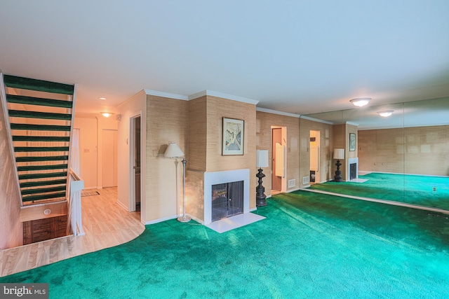 unfurnished living room with ornamental molding, carpet, and a fireplace with flush hearth