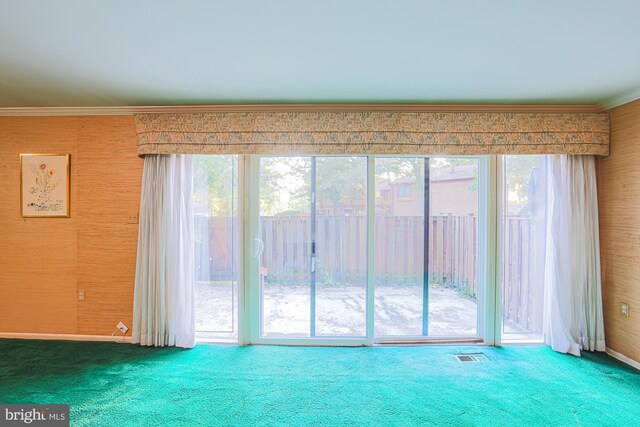 carpeted empty room featuring ornamental molding, visible vents, and wallpapered walls