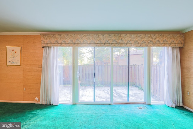 carpeted spare room with wallpapered walls, visible vents, and ornamental molding