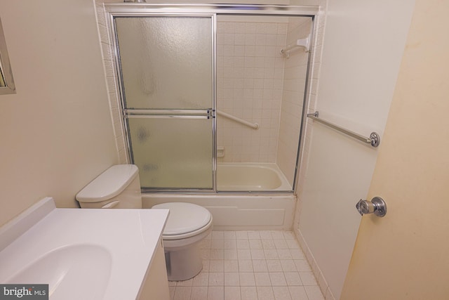 bathroom featuring enclosed tub / shower combo, toilet, vanity, baseboards, and tile patterned floors