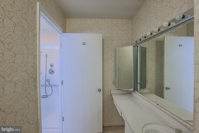 bathroom featuring wallpapered walls and vanity