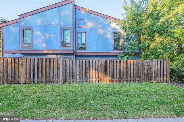 view of side of home with a yard and fence