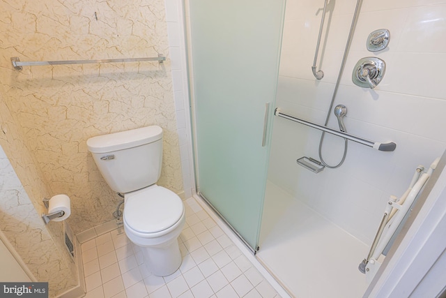 bathroom featuring toilet, a stall shower, and tile patterned flooring