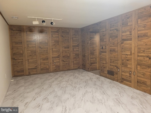 unfurnished room featuring visible vents, marble finish floor, and rail lighting