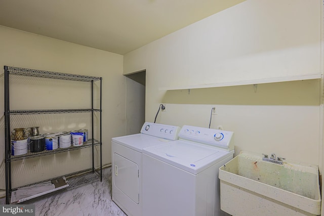 washroom featuring laundry area, a sink, marble finish floor, and washing machine and clothes dryer