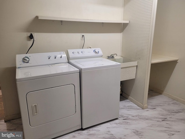 washroom featuring laundry area, a sink, baseboards, washer and dryer, and marble finish floor