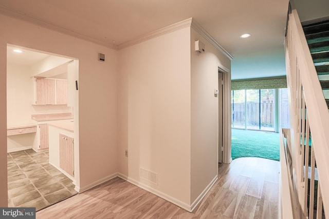 hall with ornamental molding, visible vents, and light wood-style flooring