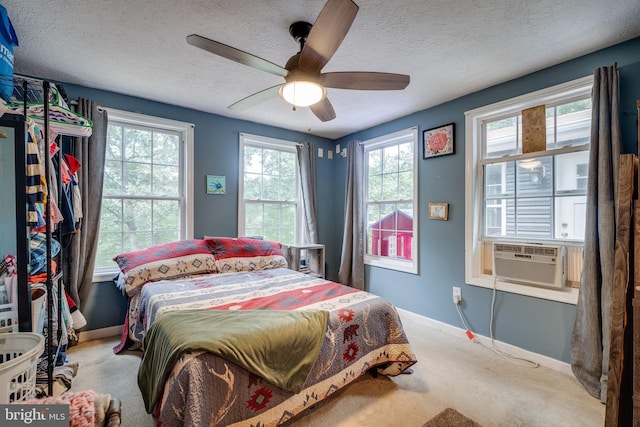 bedroom featuring carpet flooring, a textured ceiling, ceiling fan, and cooling unit