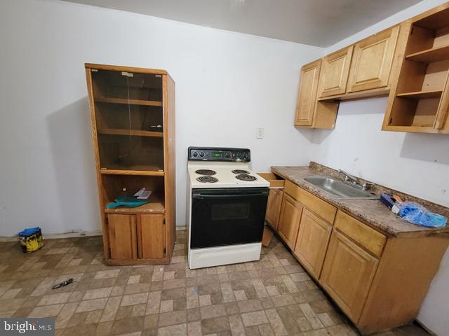 kitchen featuring sink, white electric range, light tile patterned floors, and light brown cabinets