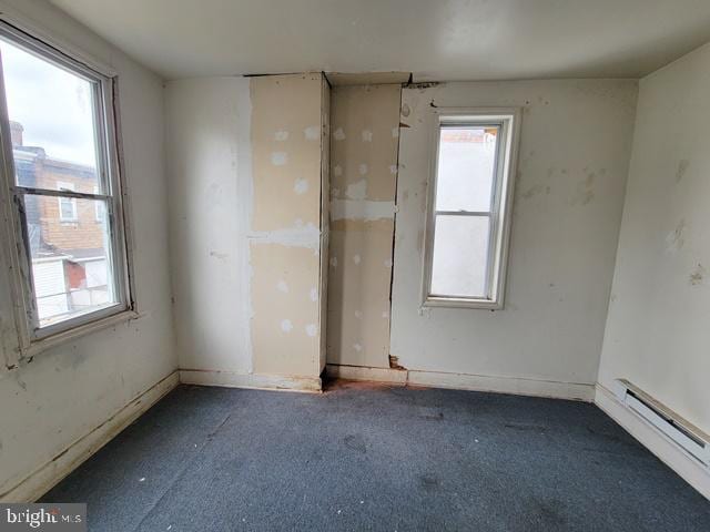 carpeted spare room with a baseboard radiator