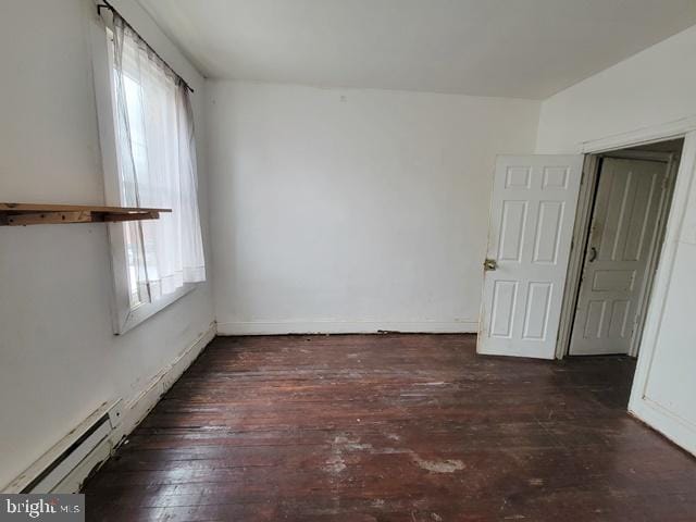 empty room with baseboard heating and wood-type flooring