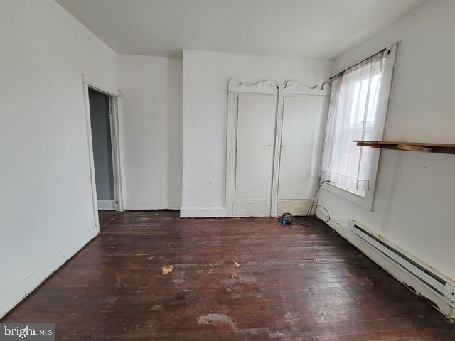 interior space with hardwood / wood-style flooring and a baseboard heating unit